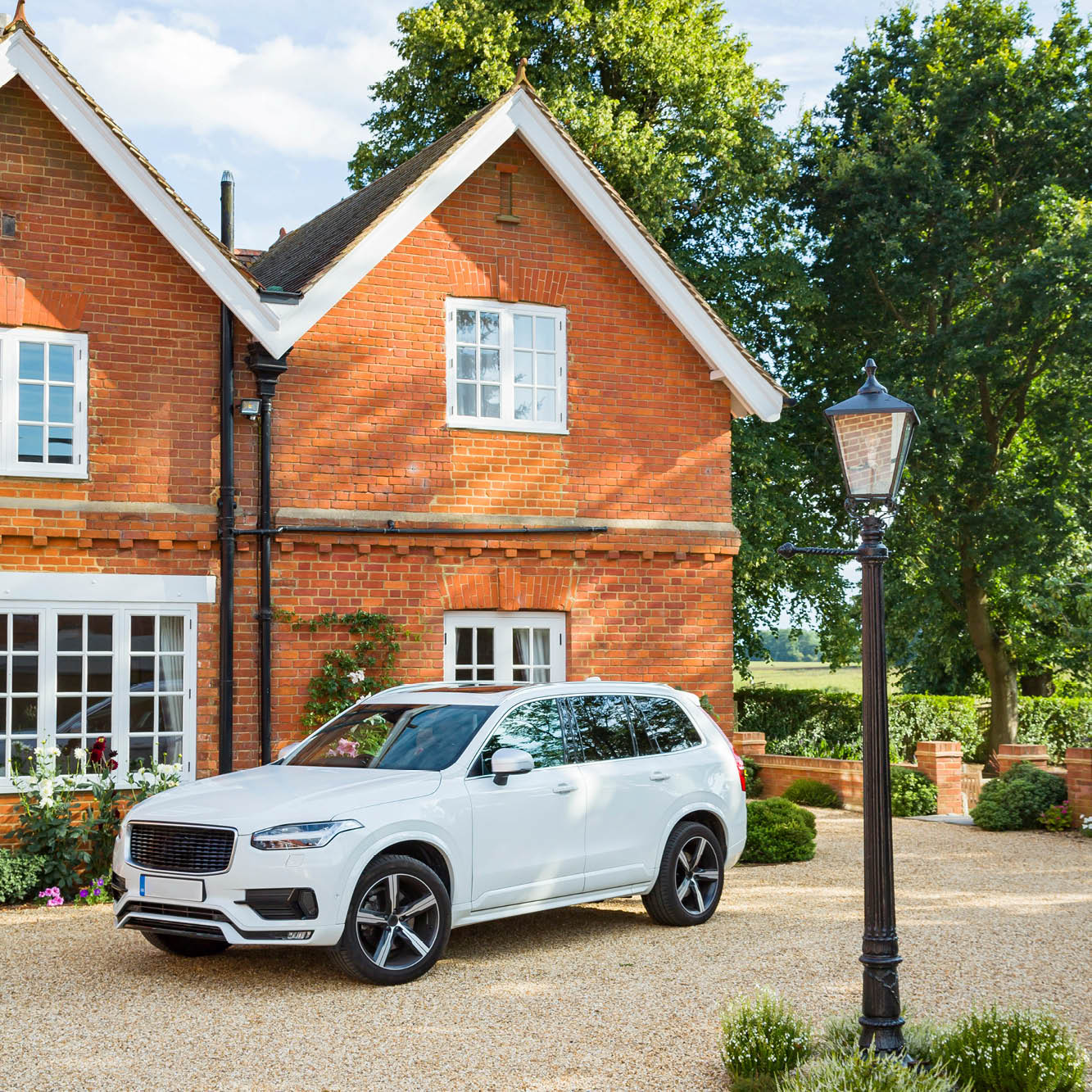 white car in front of brick house